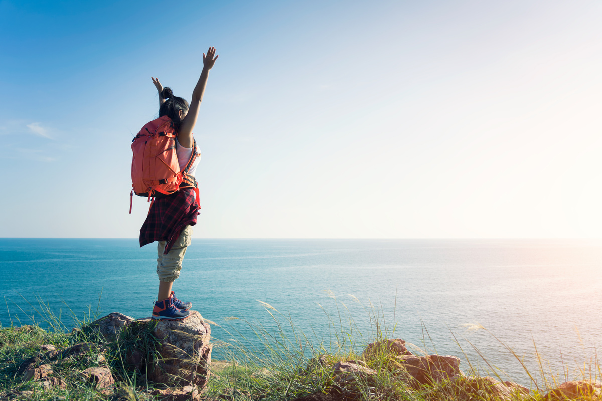 Adventure traveler woman with backpack joy relaxing in national park